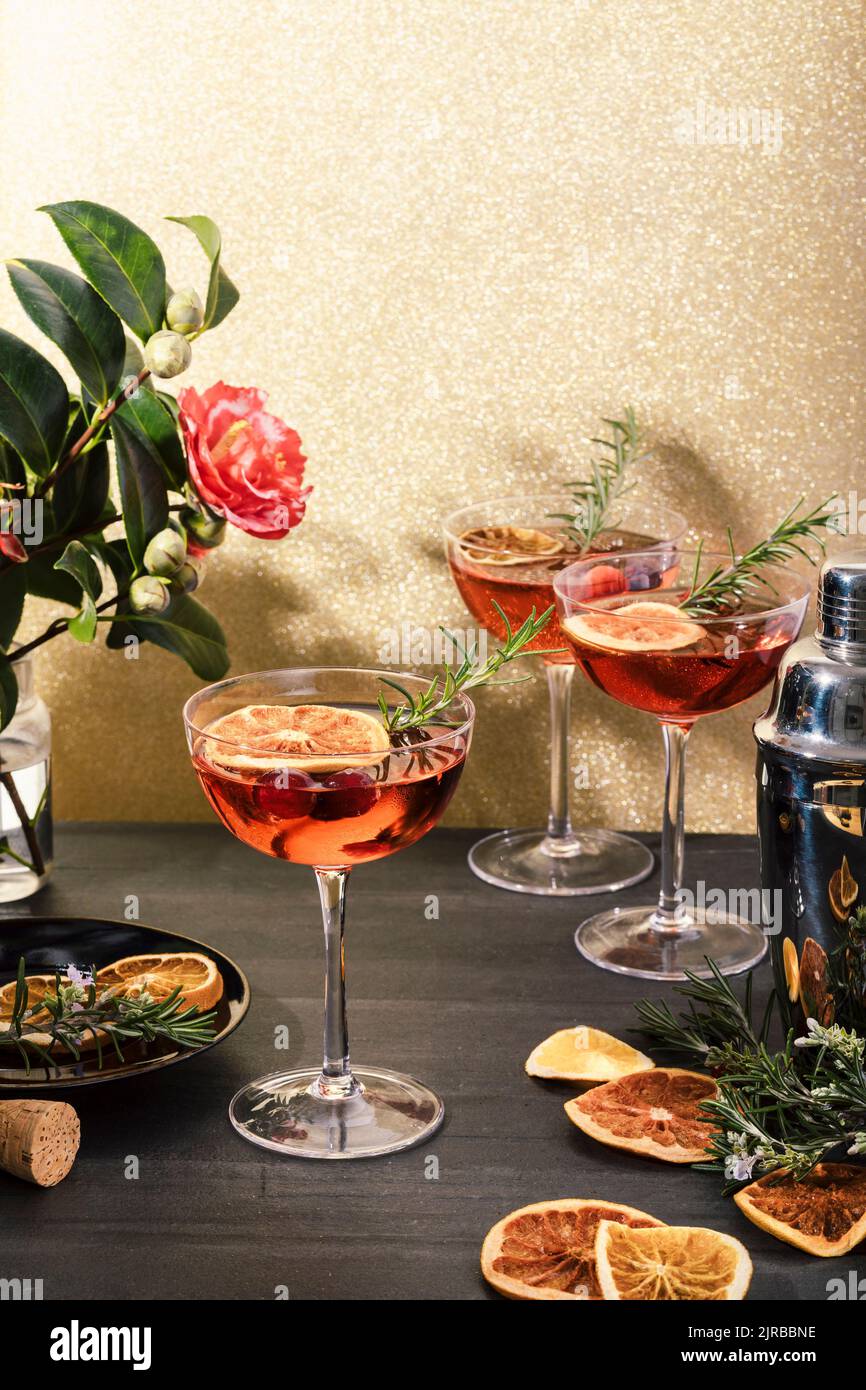 Fresh cranberry champagne cocktails garnished with orange and rosemary Stock Photo