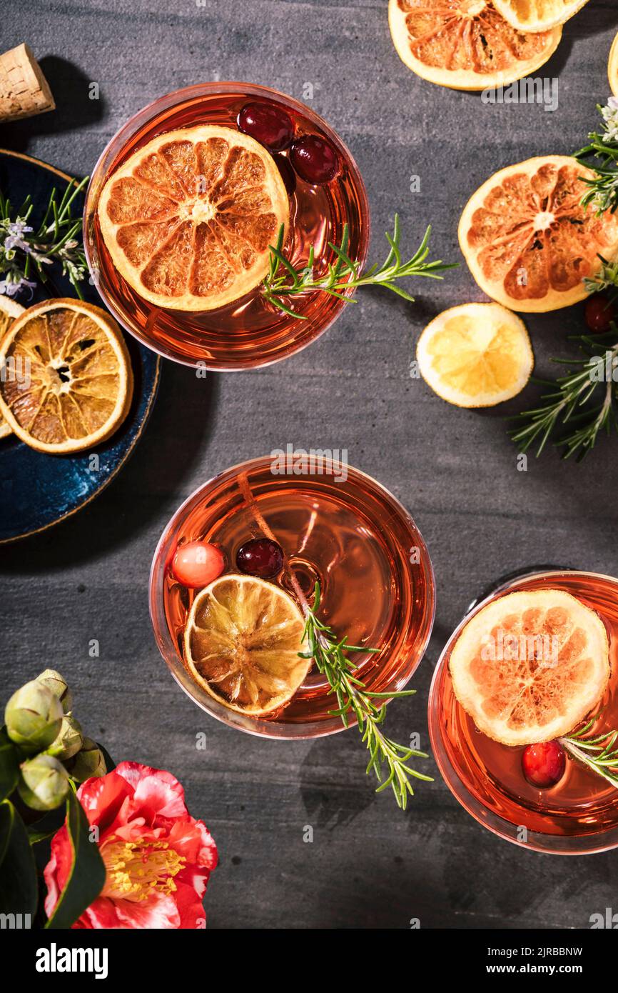 Cranberry champagne cocktails garnished with orange and rosemary Stock Photo