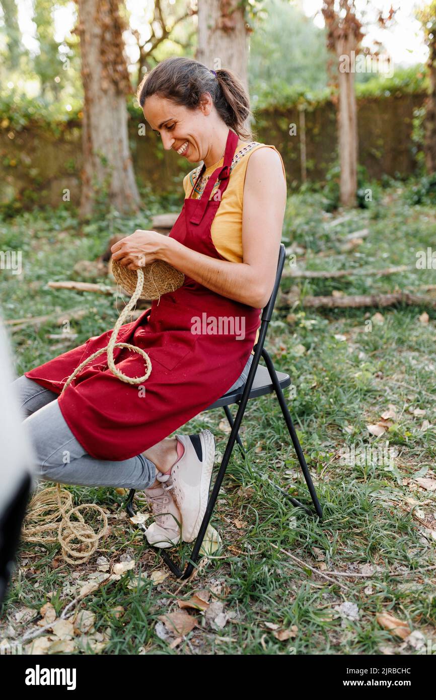 Happy craftswoman weaving esparto grass in garden Stock Photo Alamy