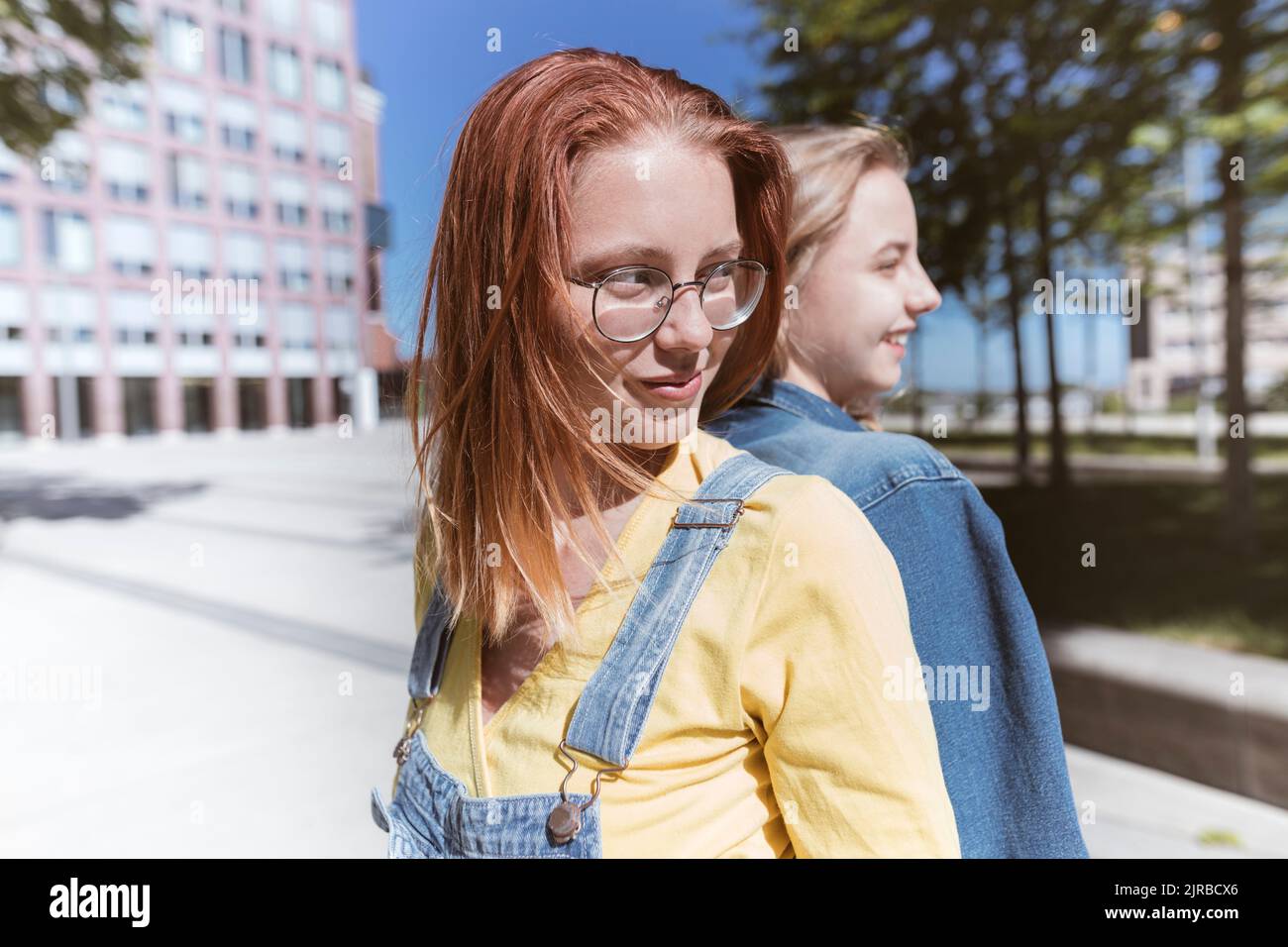 Two friends standing back to back hi-res stock photography and images ...