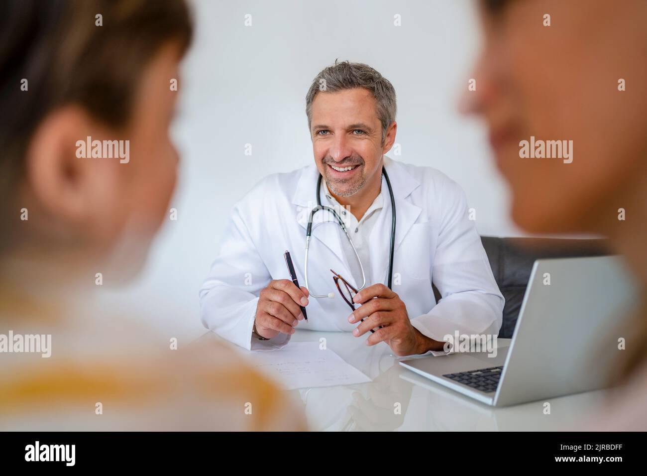 Doctor with mother and son in medical practice Stock Photo - Alamy