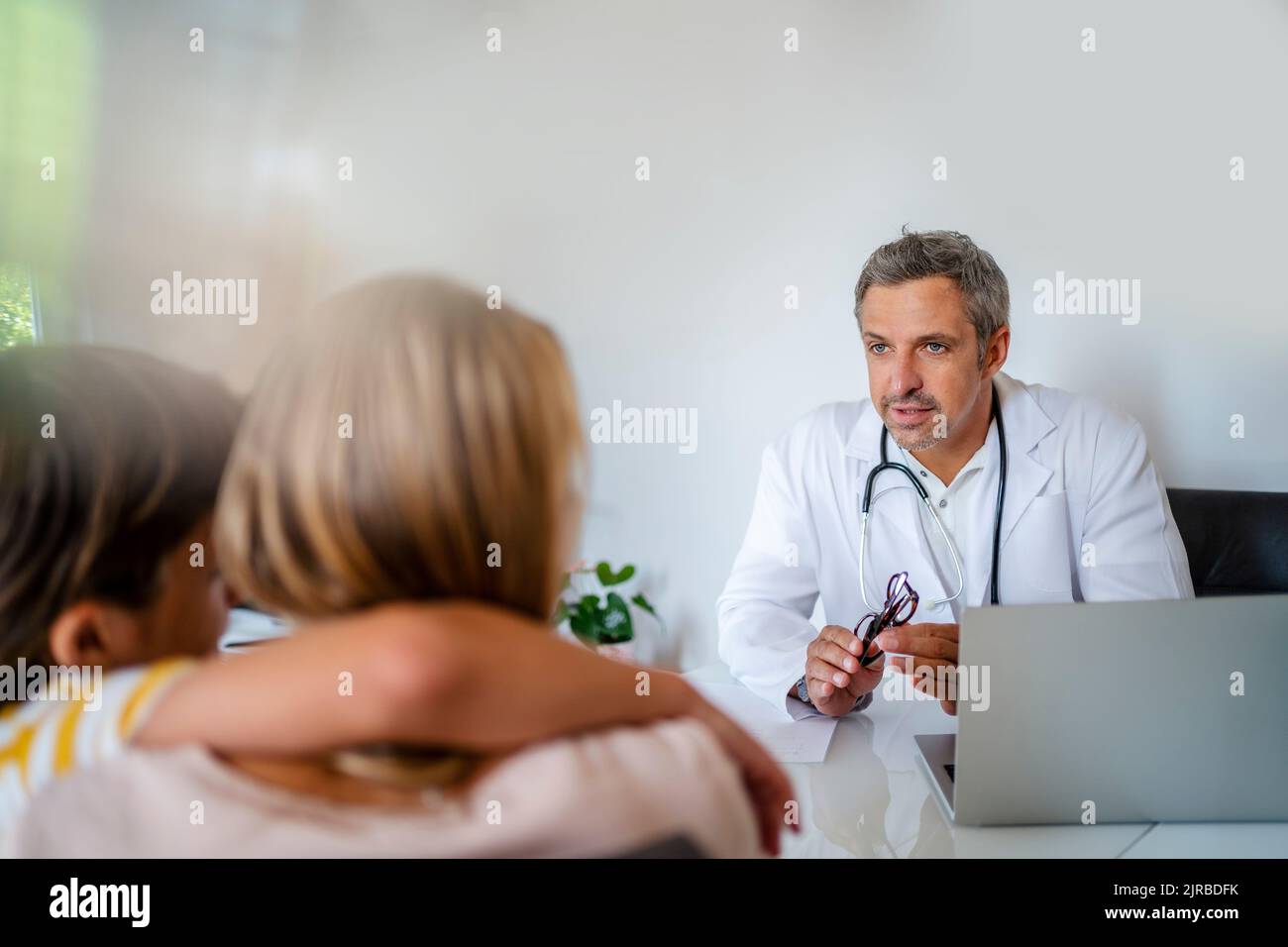 Doctor with mother and son in medical practice Stock Photo - Alamy