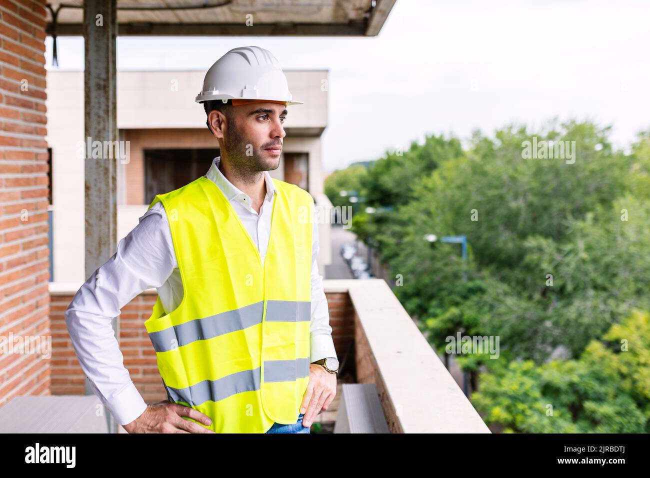 Confident smart civil architect engineer standing on apartment construction site Stock Photo