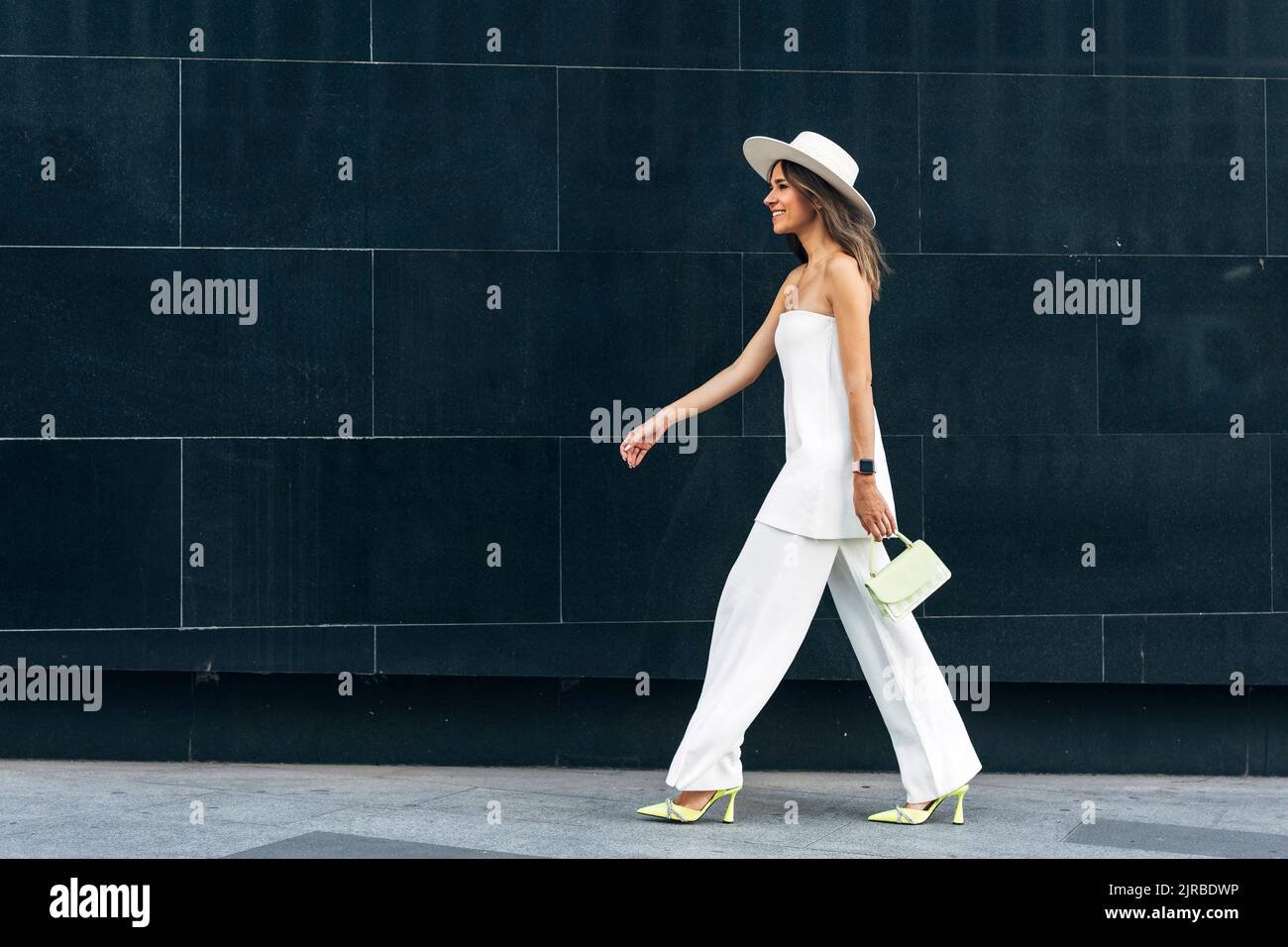 Stylish woman walking side view hi-res stock photography and