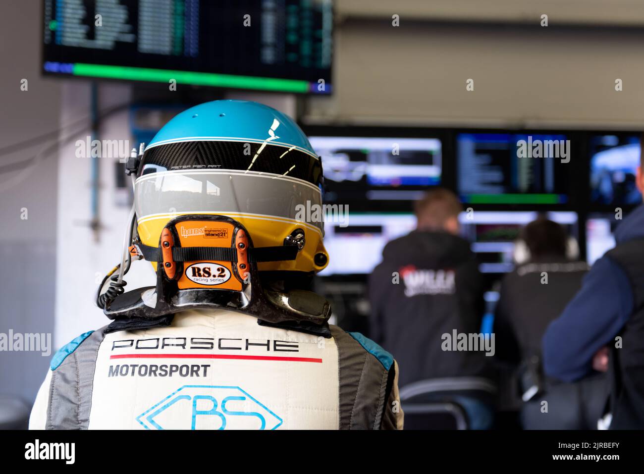 Race car driver in racing suit looking at display race info in team garage. Mugello, Italy, march 25 2022. 24 Hours series Stock Photo