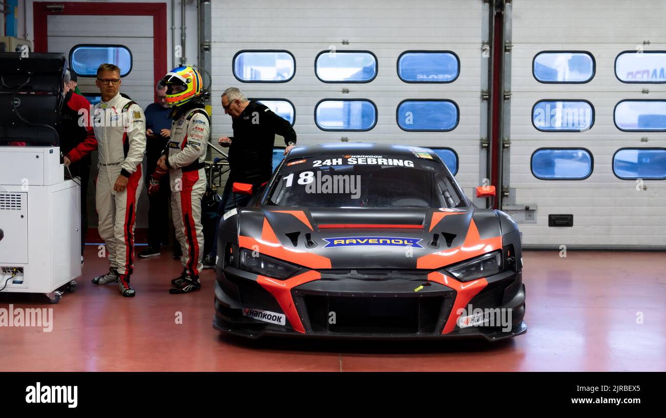 Motor sport scene, Audi R8 super car GT race standing in team garage with people and driver. Mugello, Italy, march 25 2022. 24 Hours series Stock Photo