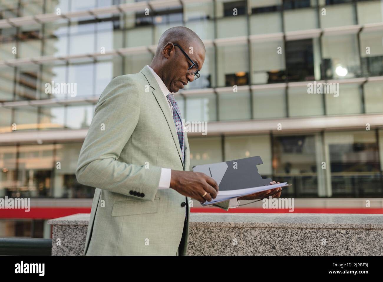 Businessman examining documents standing at financial district Stock Photo
