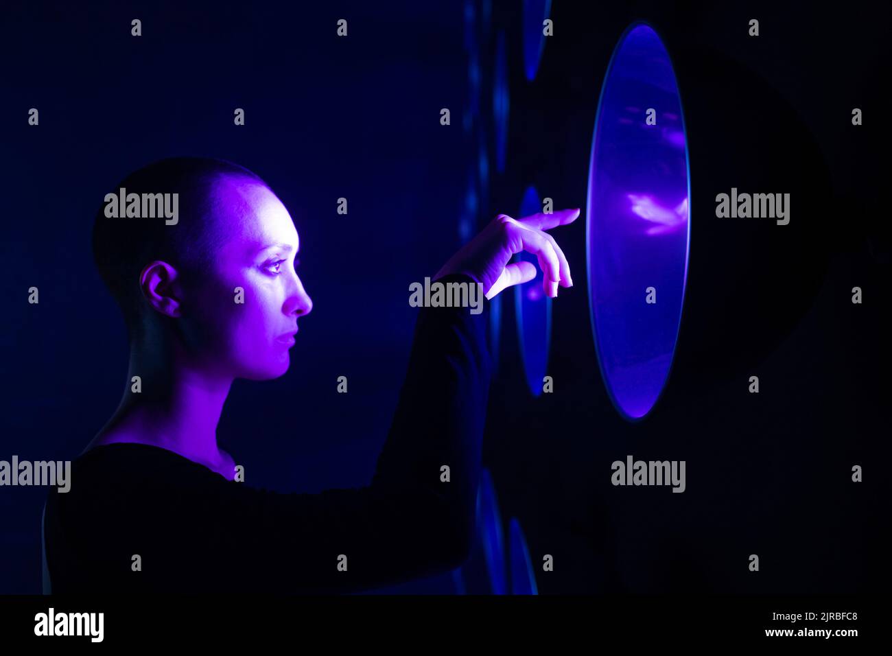 Young woman touching neon light Stock Photo