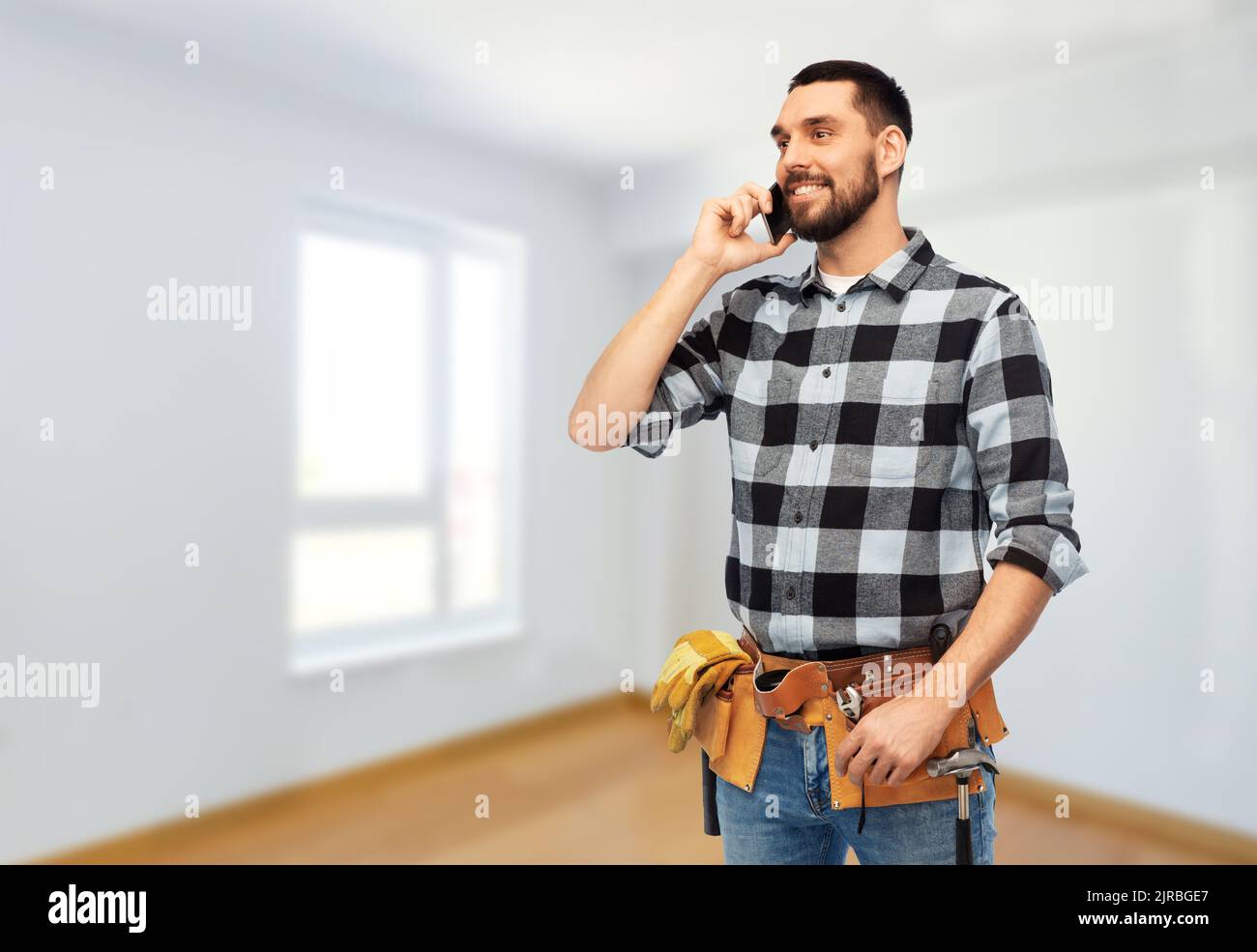 builder in helmet calling on smartphone Stock Photo