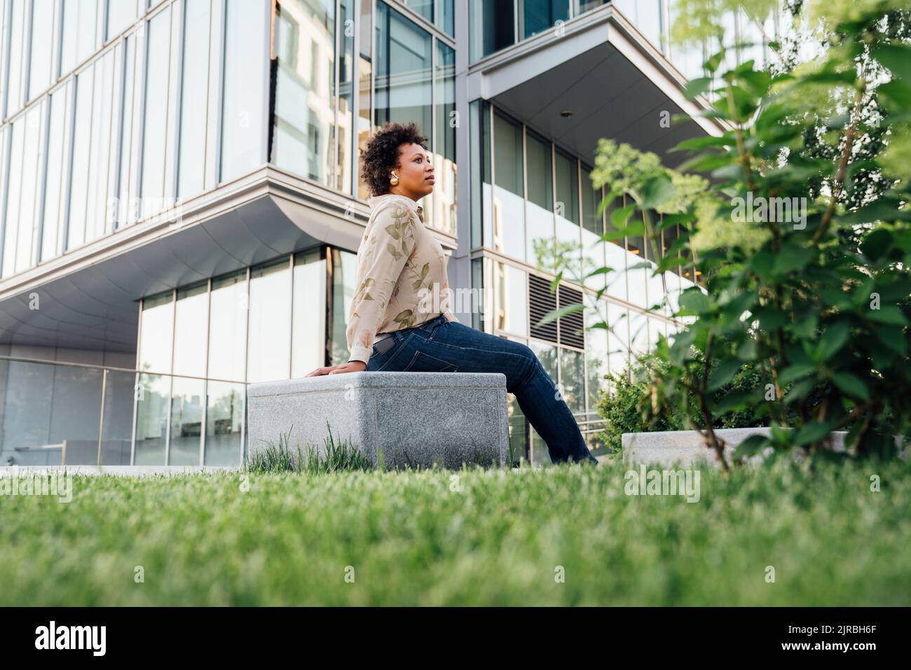 Thoughtful businesswoman sitting on concrete block Stock Photo