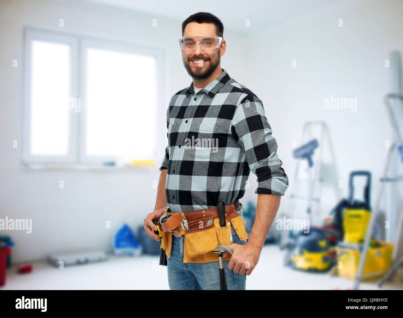 happy male worker or builder with tool belt Stock Photo