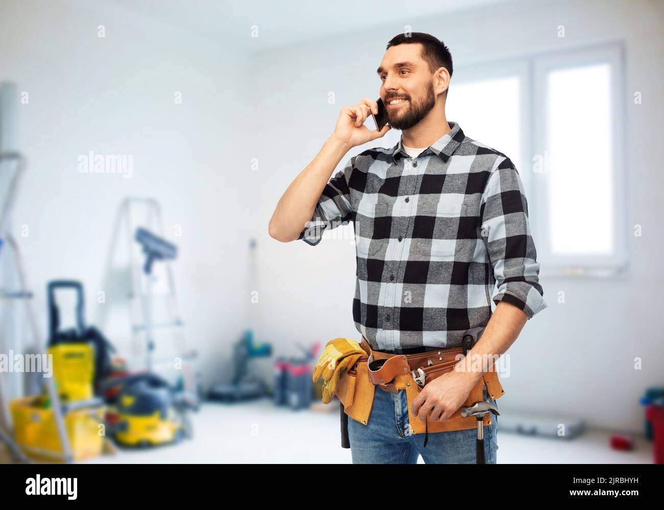 builder in helmet calling on smartphone Stock Photo