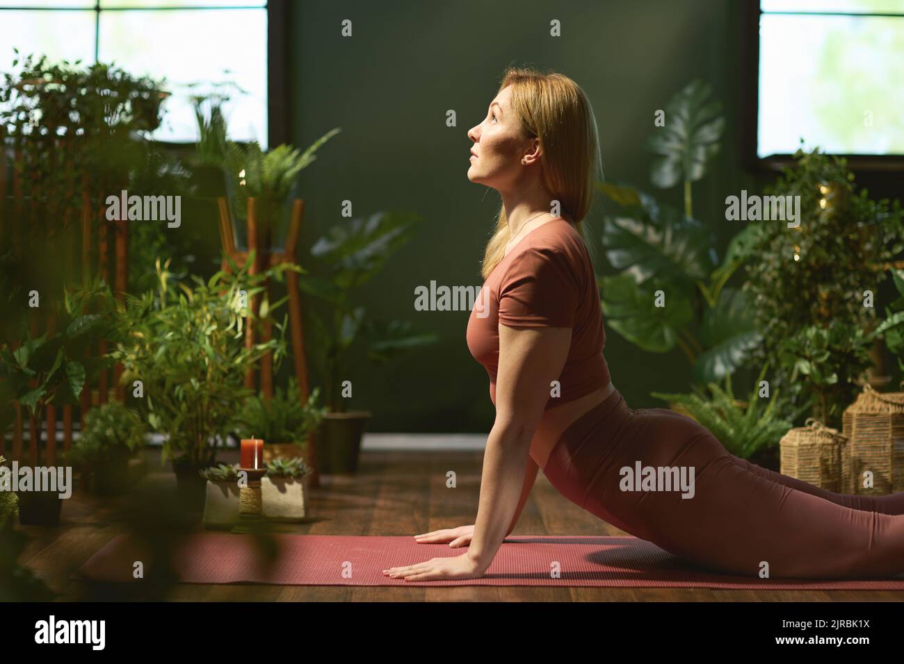 modern woman in the modern green living room doing yoga. Stock Photo