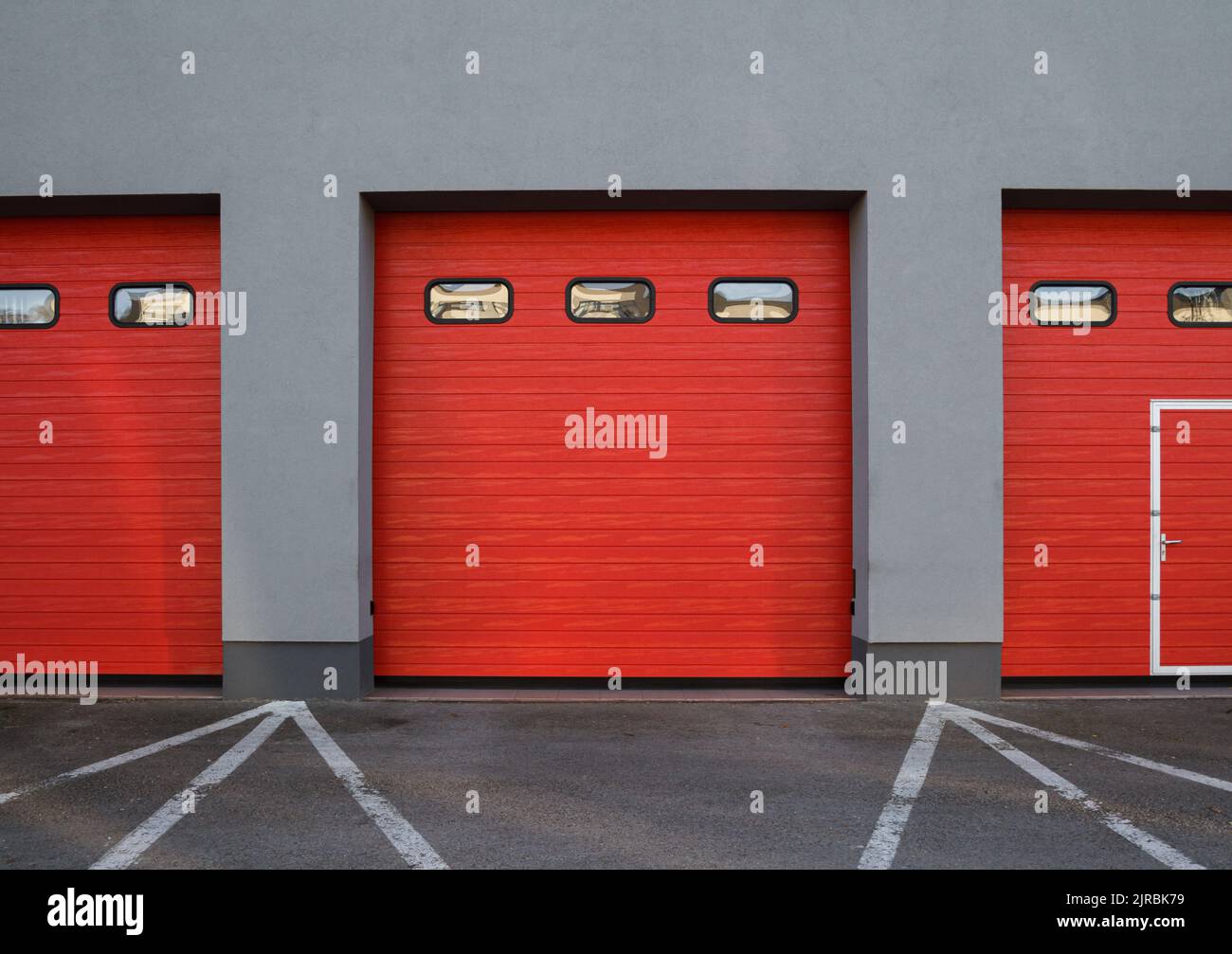 Entrance gate to the fire station. Red automated garage sectional door. Stock Photo