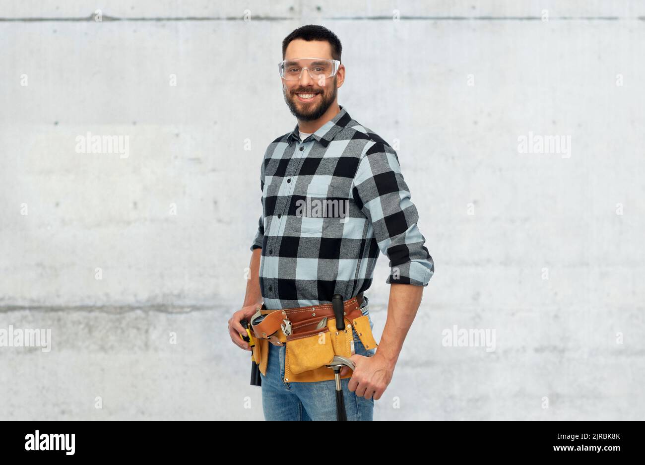 happy male worker or builder with tool belt Stock Photo