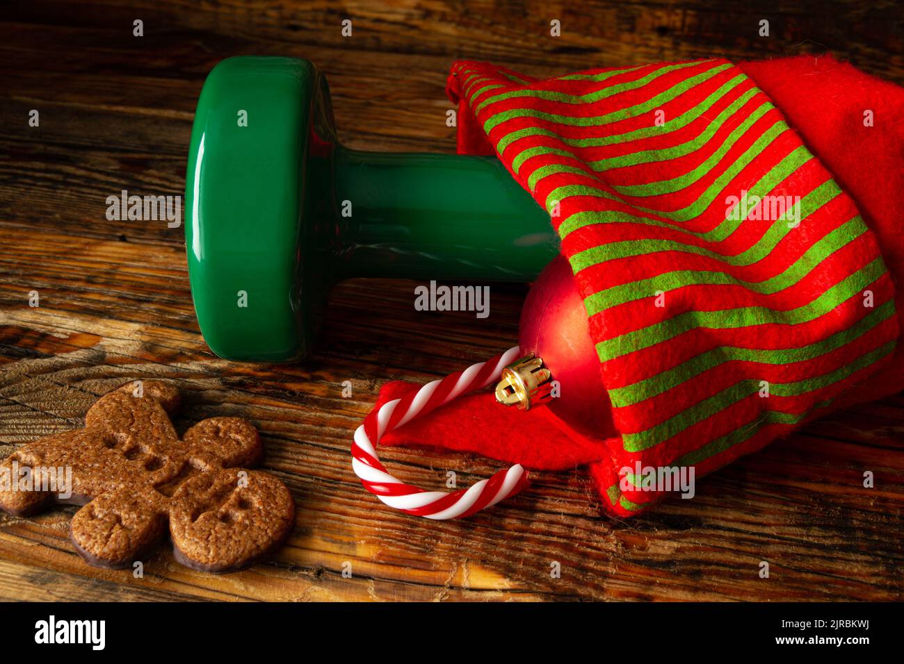 Dumbbell, candy cane, bauble in a stocking. Exercise equipment as