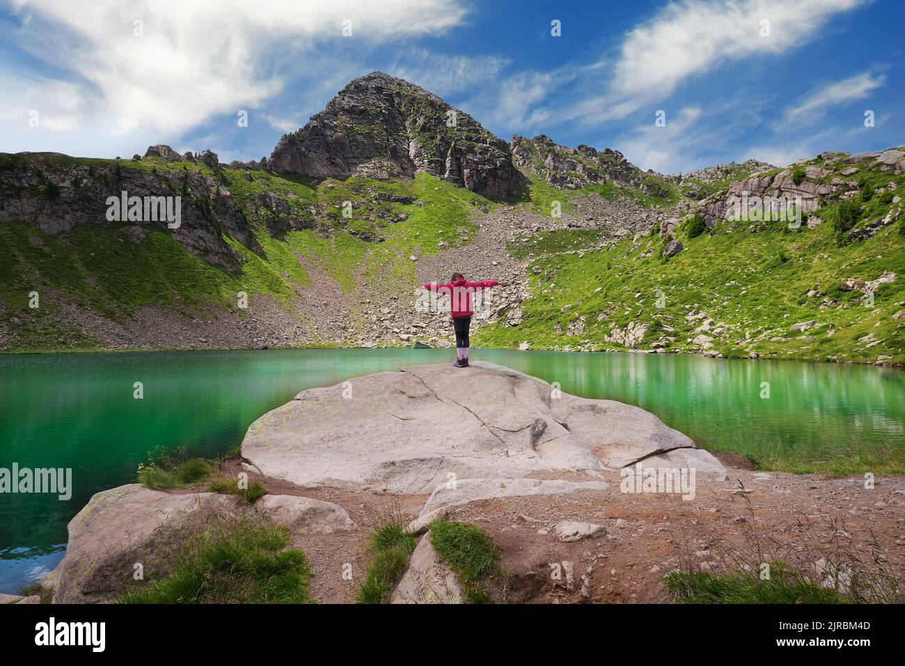 little girl looking with open arms at the bombasel lake in the ...