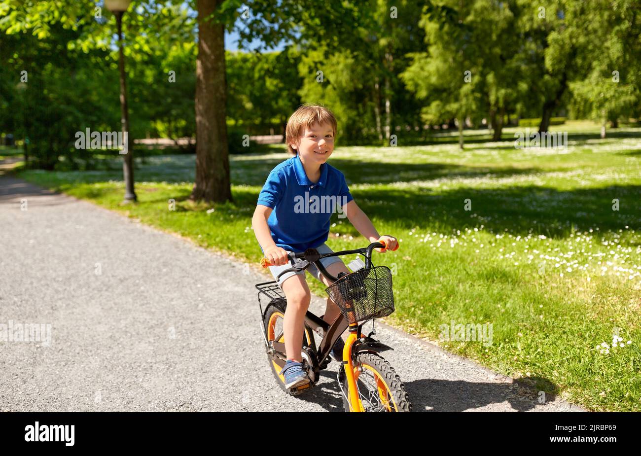 happy little boy riding bicycle at summer park Stock Photo - Alamy