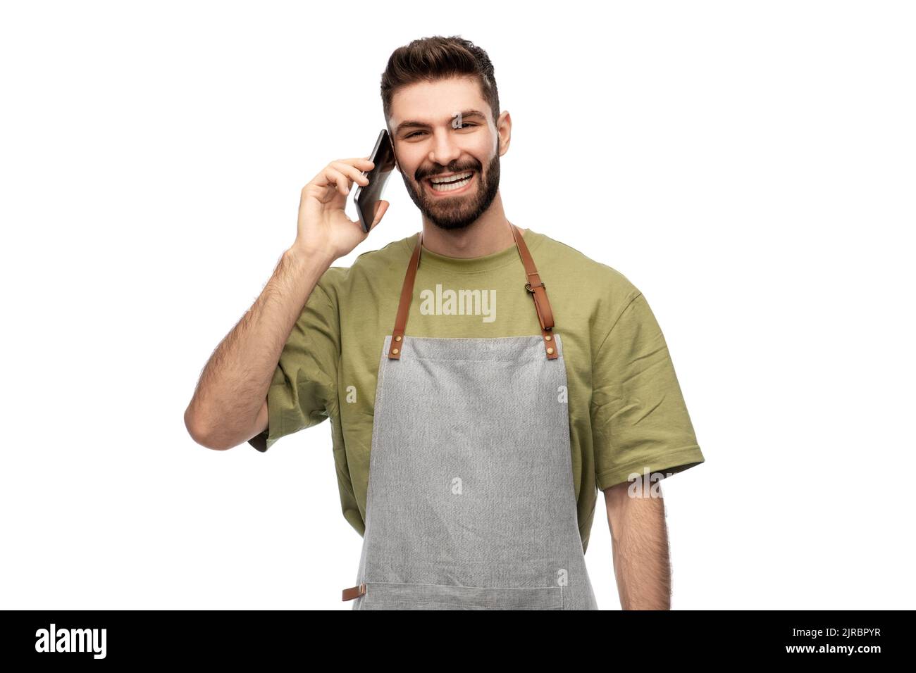 happy barman in apron calling on smartphone Stock Photo