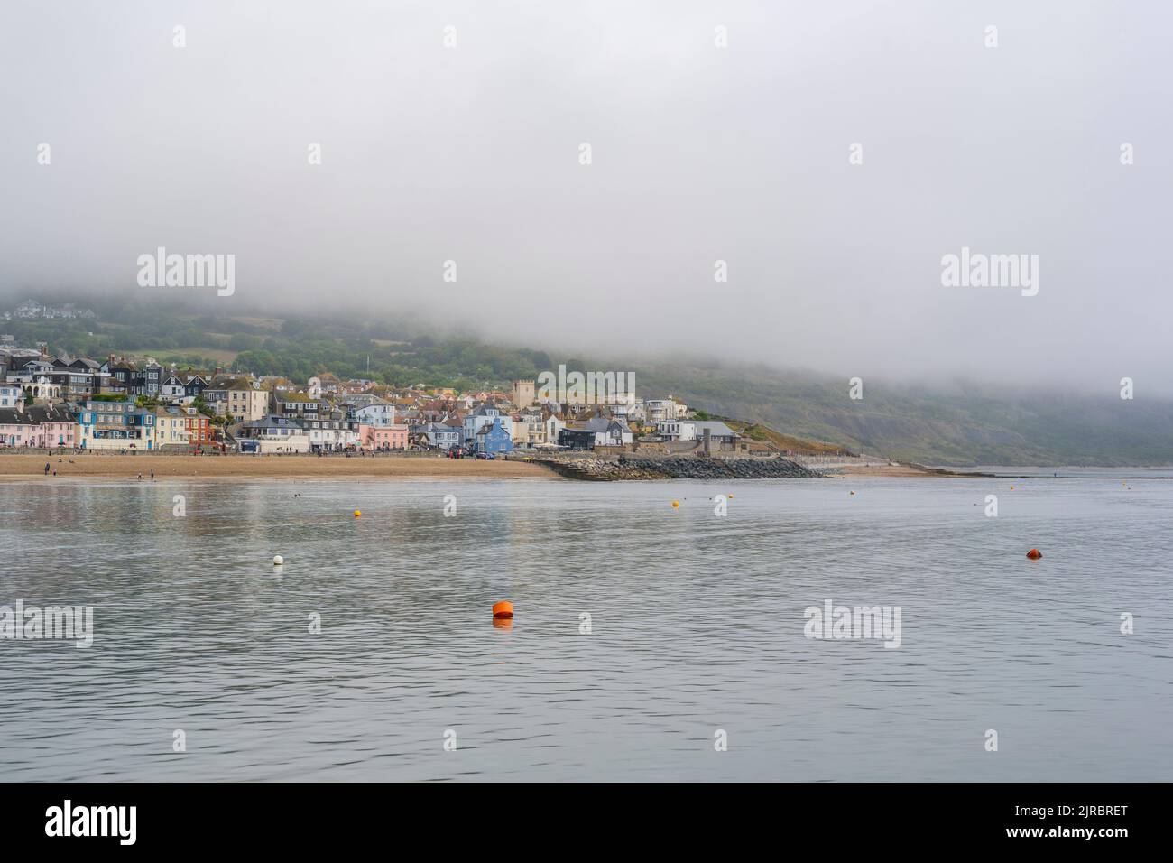Lyme Regis, Dorset, UK. 23rd Aug, 2022. UK Weather: Thick sea mist hangs above the seaside resort town of Lyme Regis at the start of a warm and muggy day with sunny spells. The weather is set to improve, becoming increasingly bright and sunny as we head towards the August bank holiday weekend. Credit: Celia McMahon/Alamy Live News Stock Photo