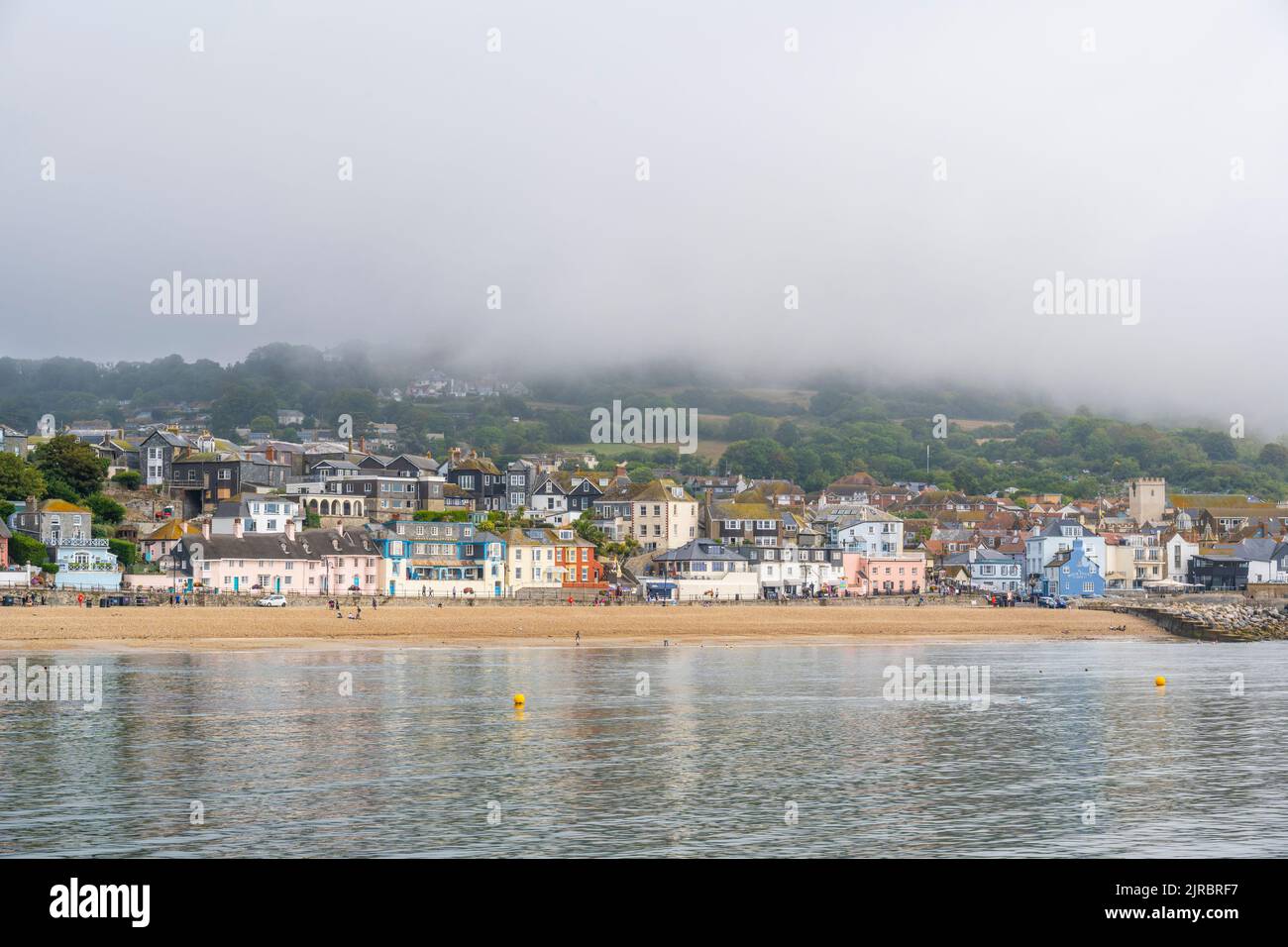 Lyme Regis, Dorset, UK. 23rd Aug, 2022. UK Weather: Thick sea mist hangs above the seaside resort town of Lyme Regis at the start of a warm and muggy day with sunny spells. The weather is set to improve, becoming increasingly bright and sunny as we head towards the August bank holiday weekend. Credit: Celia McMahon/Alamy Live News Stock Photo