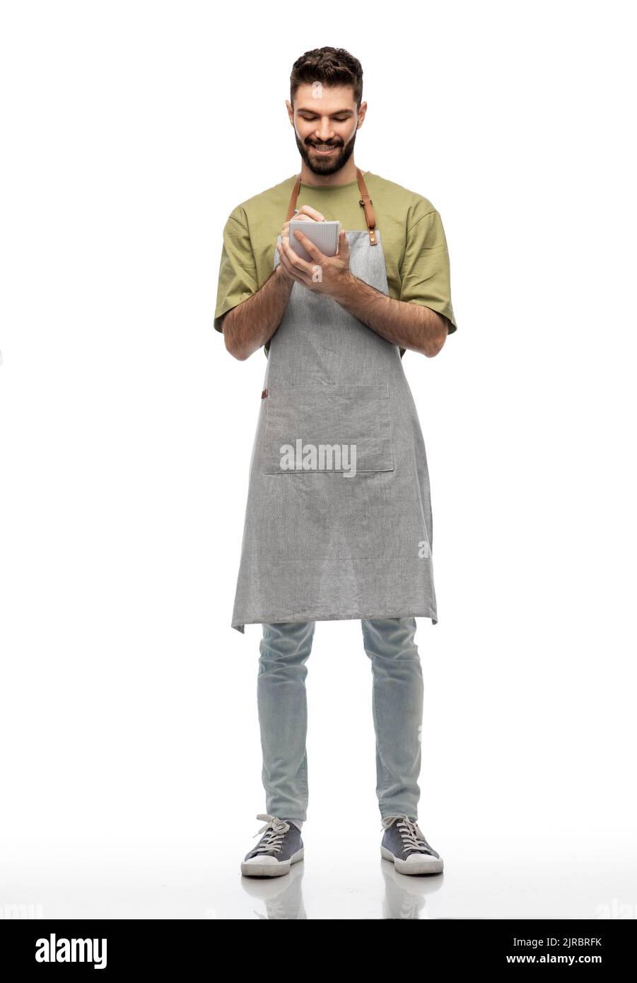 smiling waiter in apron taking notes to notepad Stock Photo