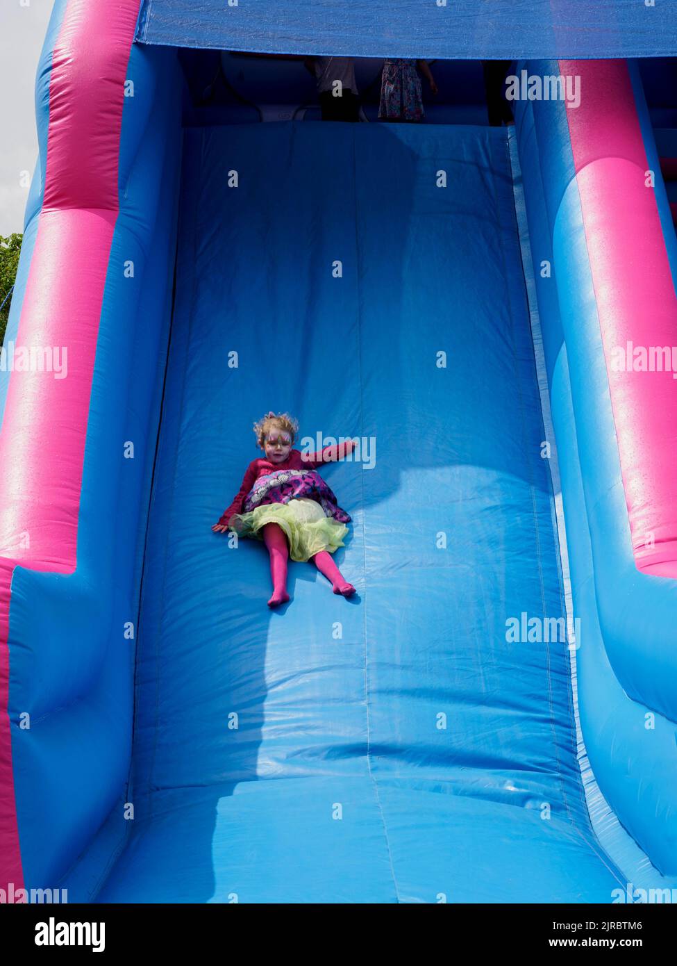 Young child sliding down a large slide, UK Stock Photo