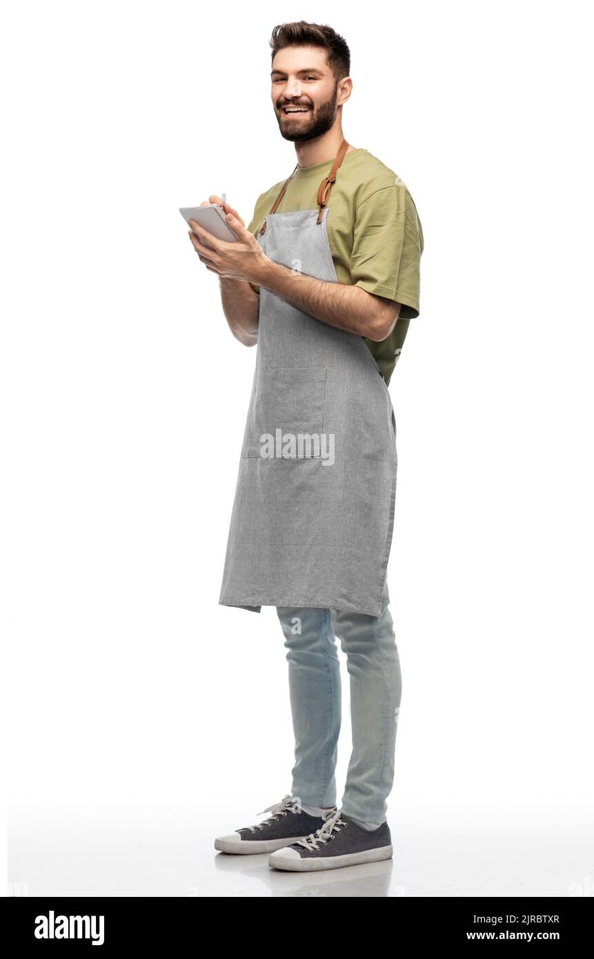 smiling waiter in apron taking notes to notepad Stock Photo