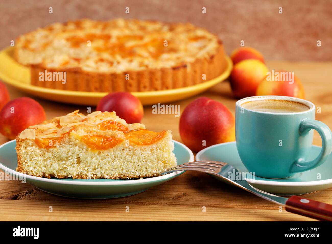 Closeup piece of homemade pie with apricots and cup of coffee espresso on wooden table. Shallow focus. Stock Photo