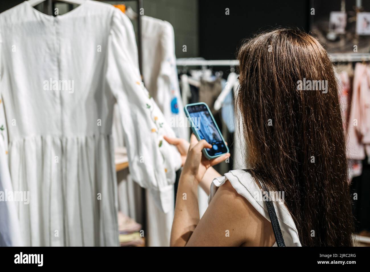 and sell online. Woman taking picture of clothes in the shop