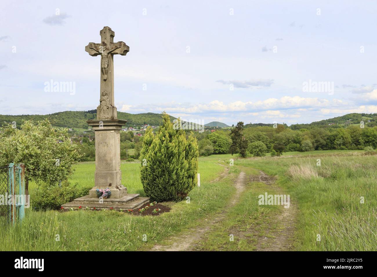 An old stone cross by the trail in Carphatian Mountains. Stock Photo