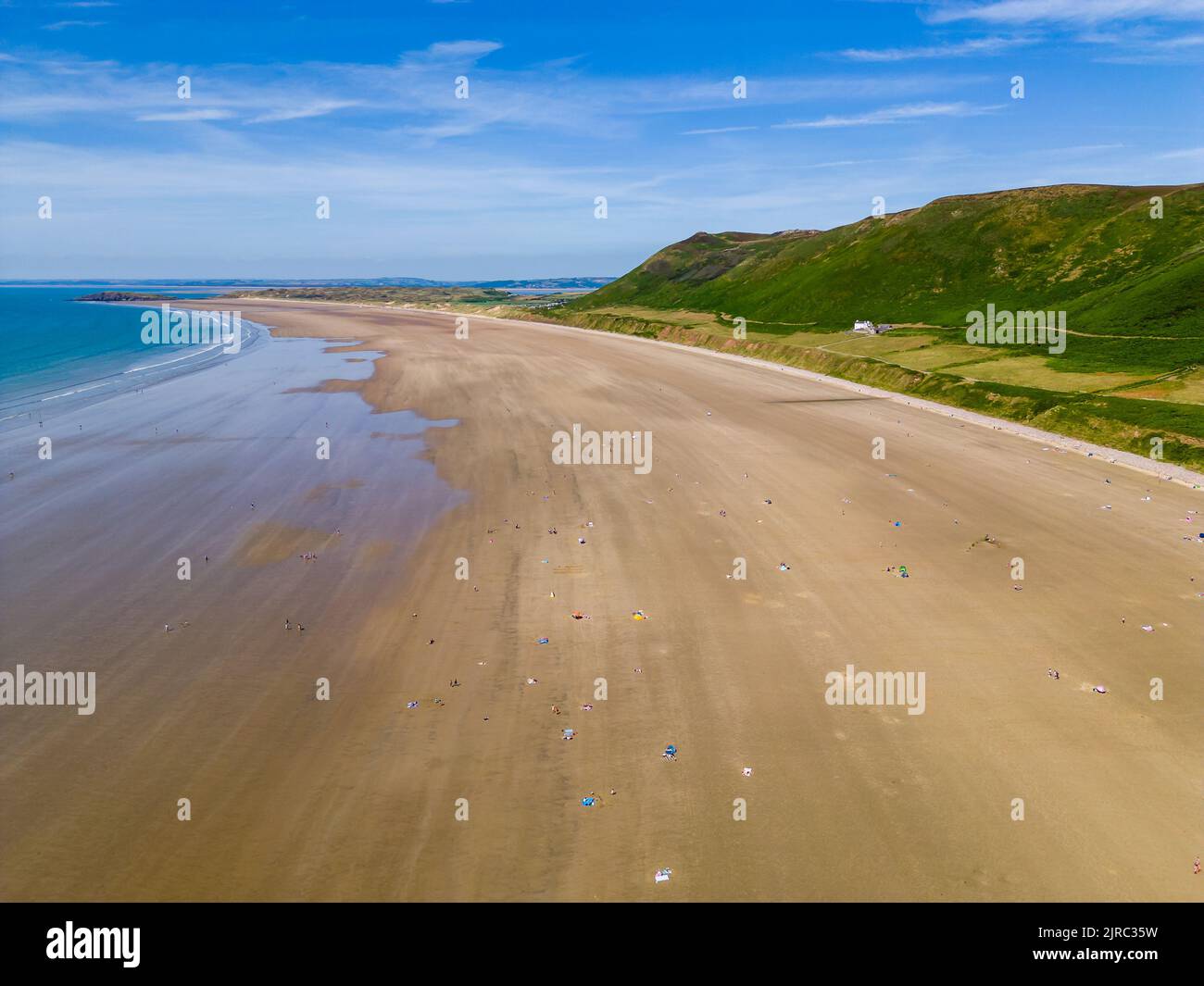 Aerial view of tourists on a huge, wide sandy beach on the coast of Wales (Rhossili, Gower, Wales) Stock Photo
