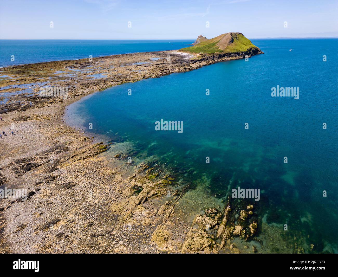 Aerial view of a causeway connecting to an island at low tide (Worms Head, Rhossili, Wales) Stock Photo