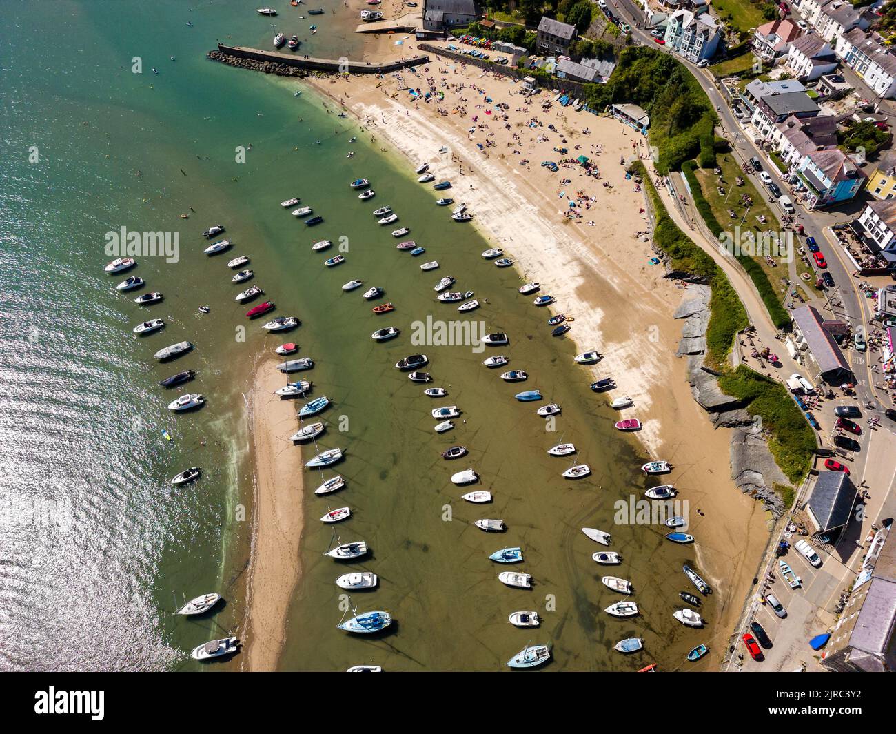Boats on the sand at low tide in the harbour of New Quay, Wales (Ceredigion) Stock Photo