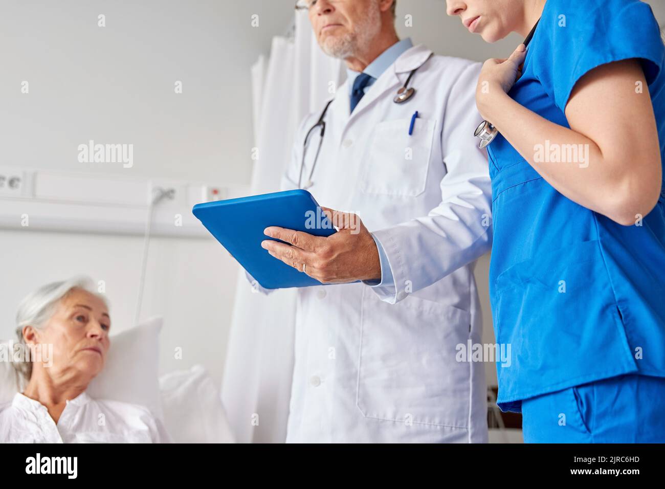 doctors with table pc and senior woman at hospital Stock Photo - Alamy