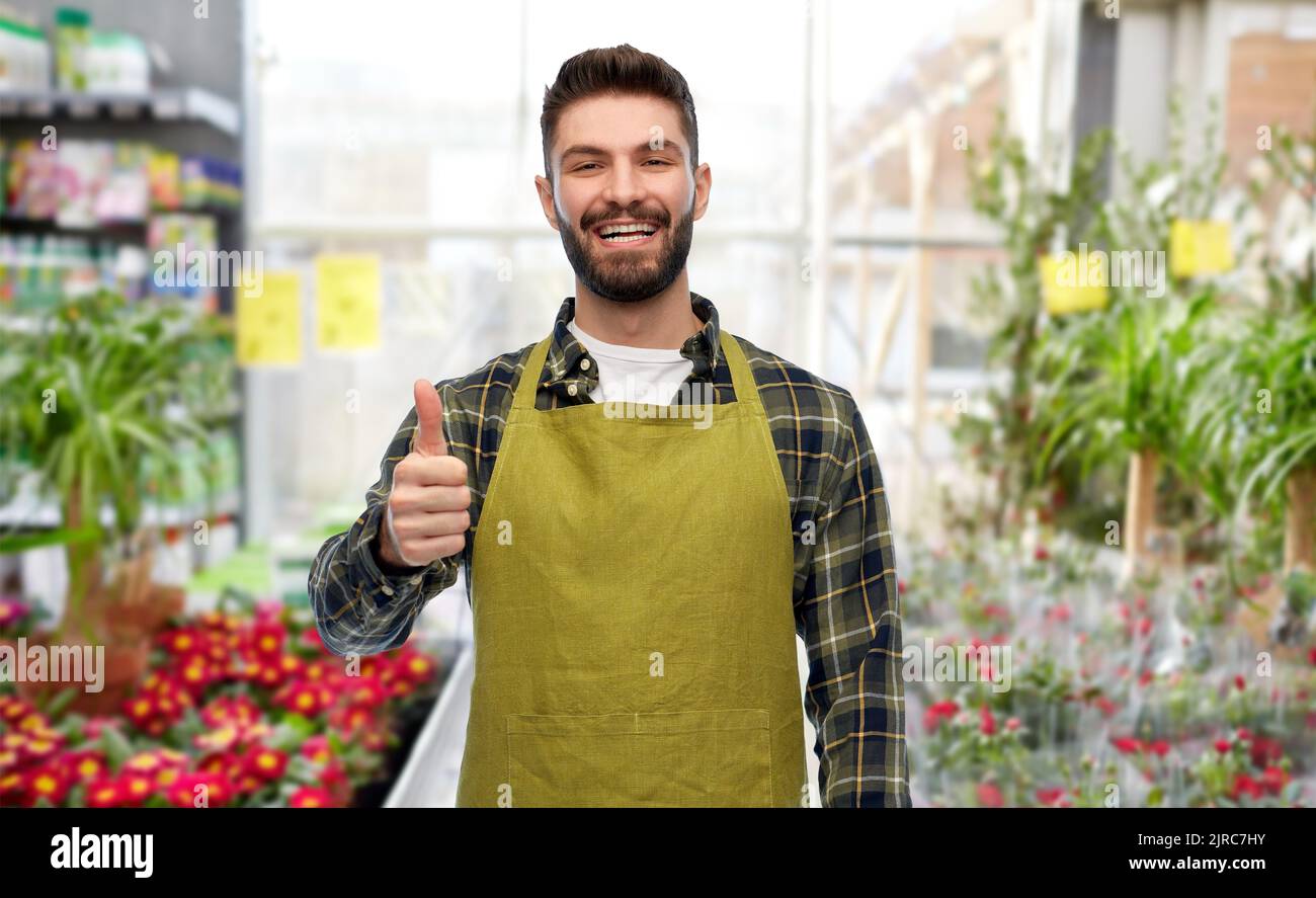 happy gardener showing thumbs up at flower shop Stock Photo - Alamy