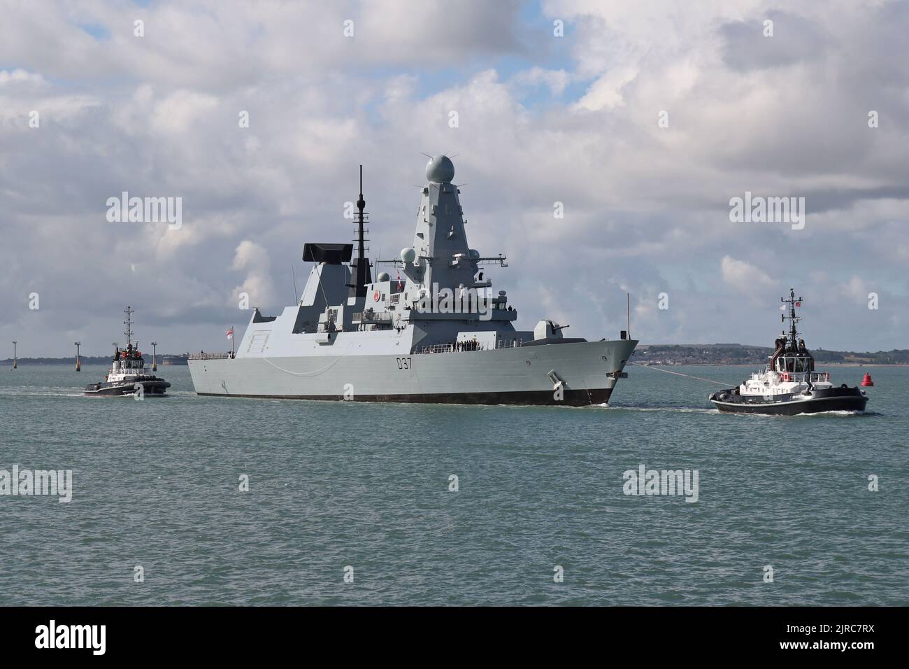 Naval Base tugs BOUNTIFUL and INDULGENT assist the Royal Navy Type 45 destroyer HMS DUNCAN into harbour Stock Photo
