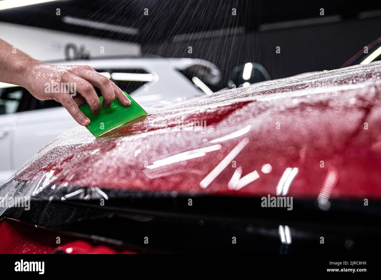 Car Color Less Man car detailing studio employee applies a colorless protective film ...