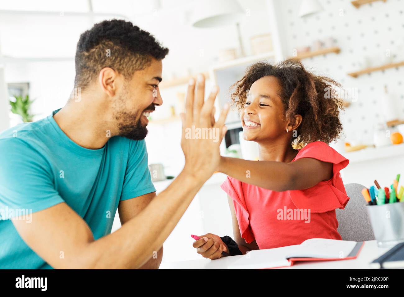 homework teaching girl high five education father children daughter familiy childhood success child african american Stock Photo