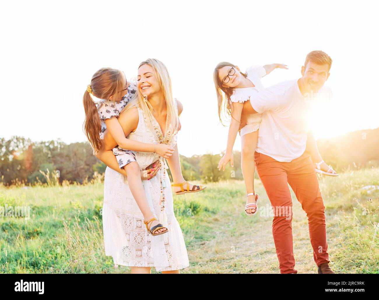 child family outdoor mother woman father girl happy happiness lifestyle having fun bonding piggyback Stock Photo