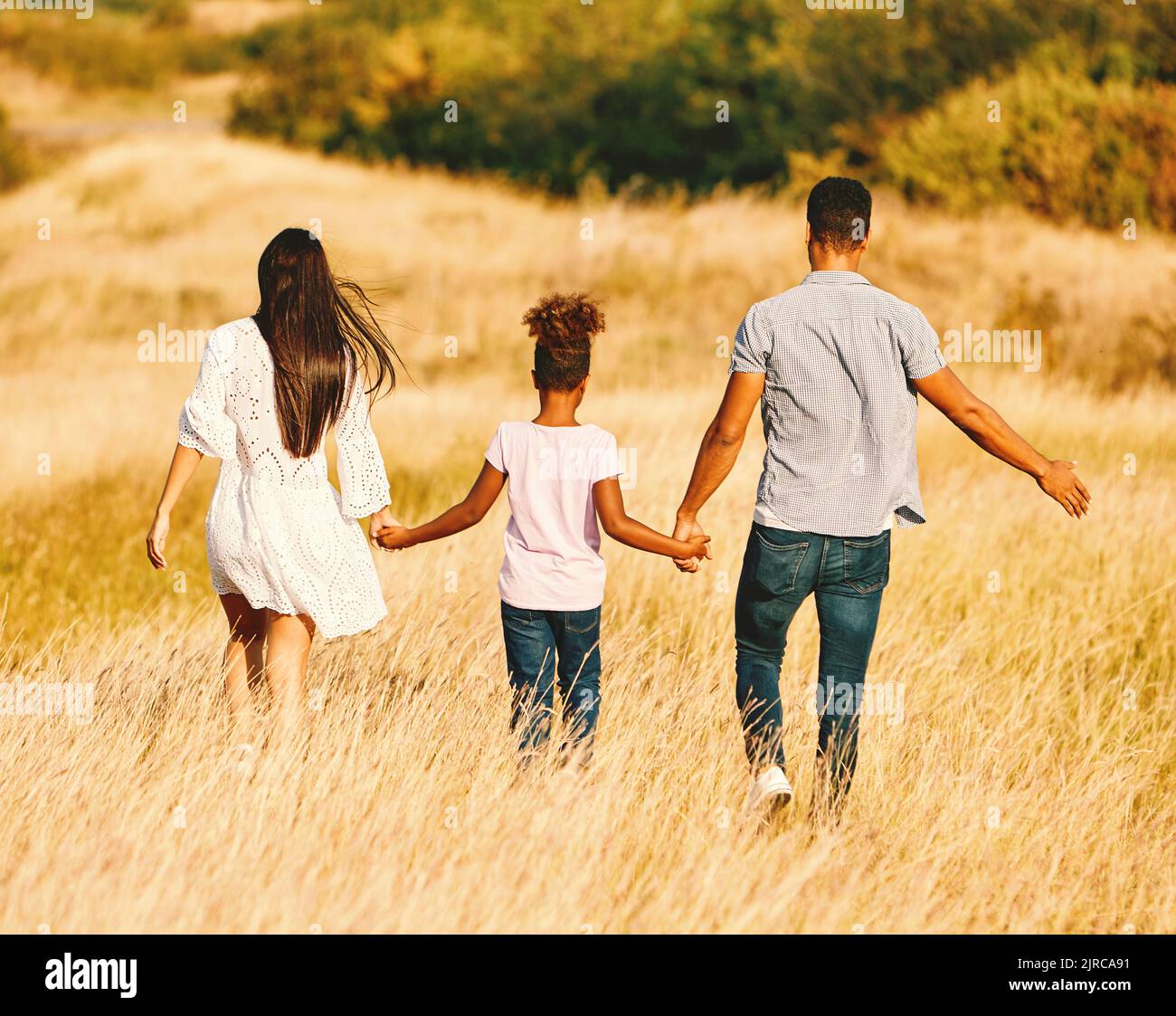 child daughter family happy mother father running active healthy carefree fun together girl walking cheerful field outdoor natur summer Stock Photo