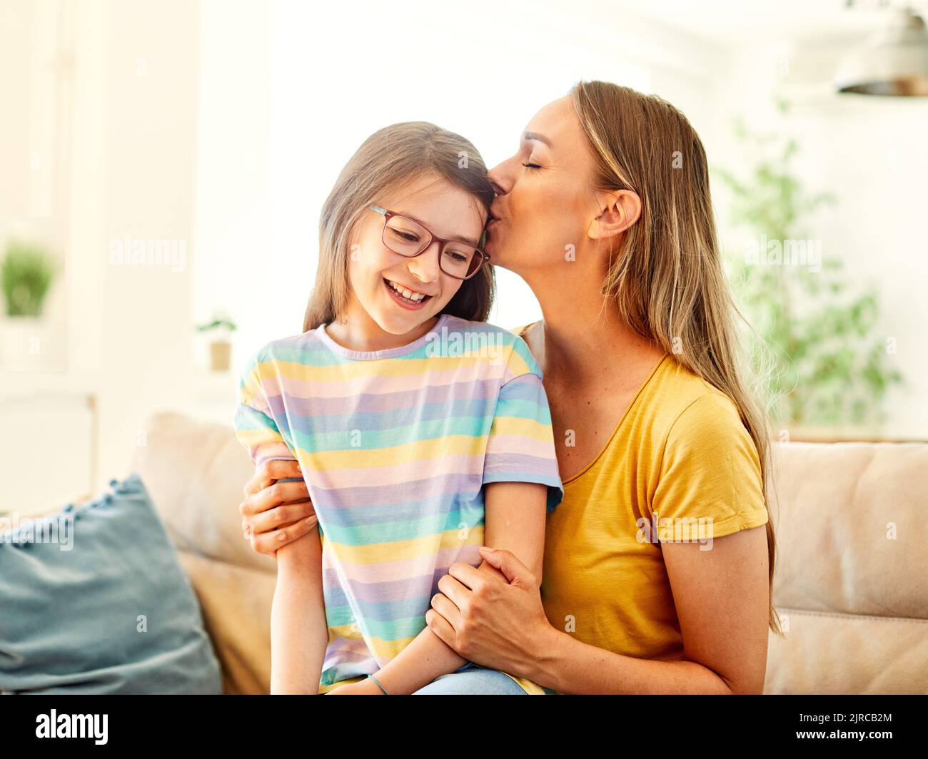 child mother family parent home woman happy playing daughter kid together indoor hug hugging kiss Stock Photo