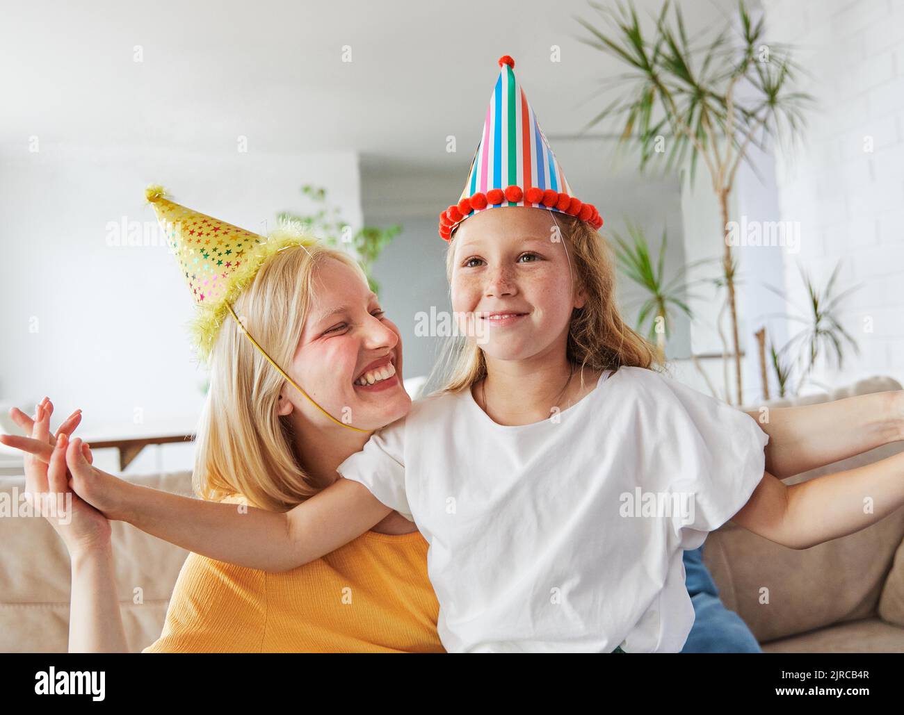 child sister fun family girl together childhood female happy daughter young lifestyle birthday party hat happiness kid togetherness mother woman Stock Photo