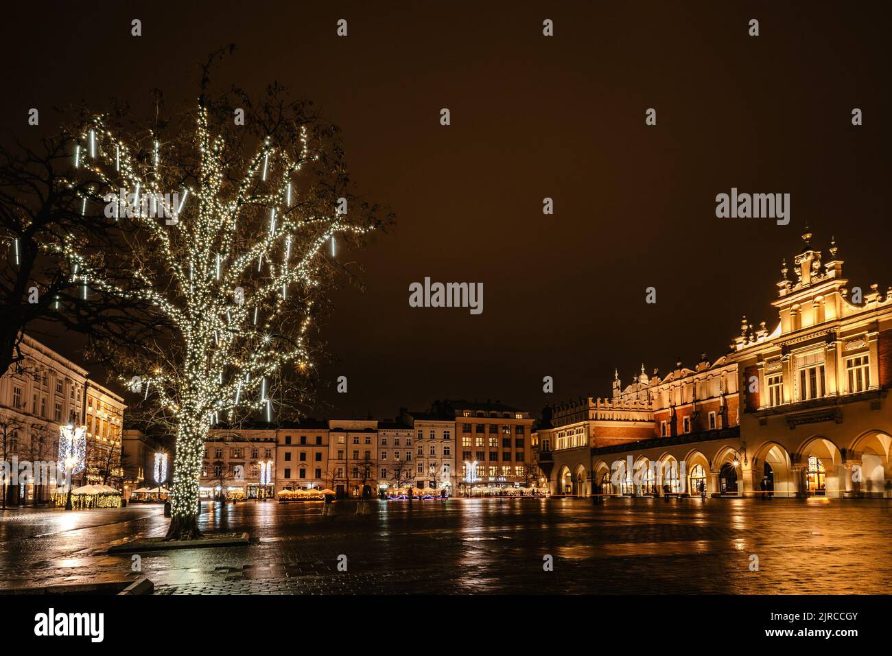 Krakow after rain,Poland.Main square with famous Christmas markets,Rynek Glowny at night with reflection,decorated Xmas tree.Festive atmosphere,blurre Stock Photo