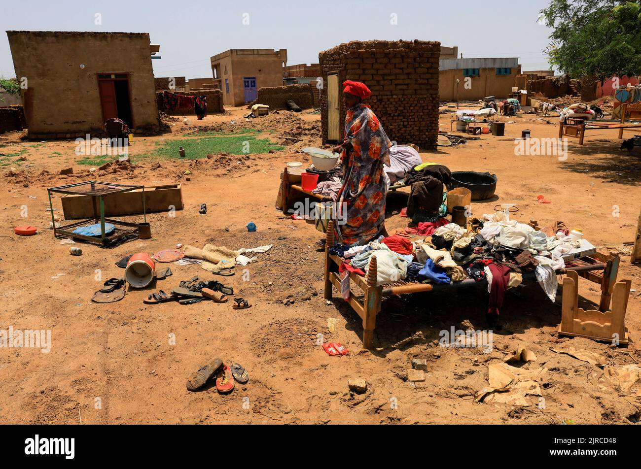 A woman walks amid ruins of her house in Al-Managil locality during floods in Jazeera State, Sudan, August 23, 2022. REUTERS/Mohamed Nureldin Abdallah Stock Photo