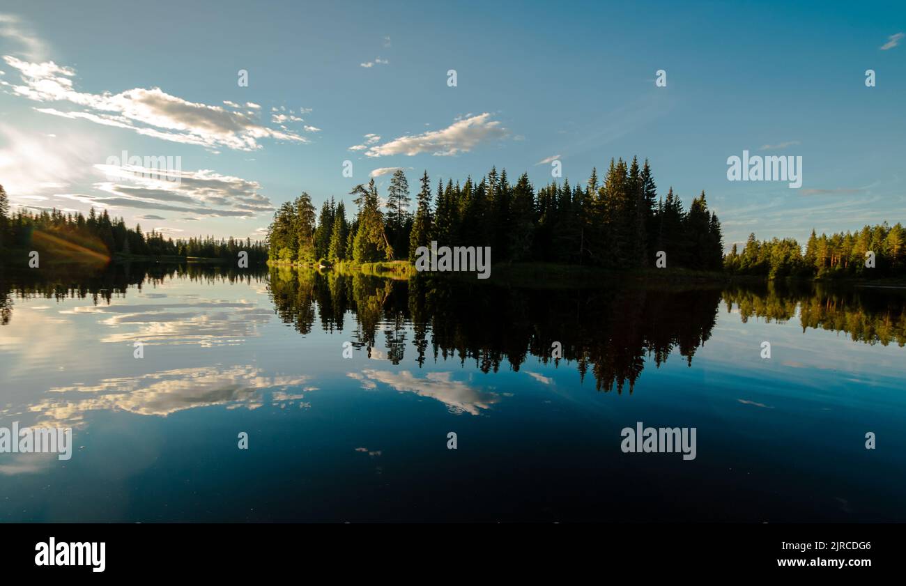 A reflection of trees and blue cloudy sky on the water Stock Photo - Alamy