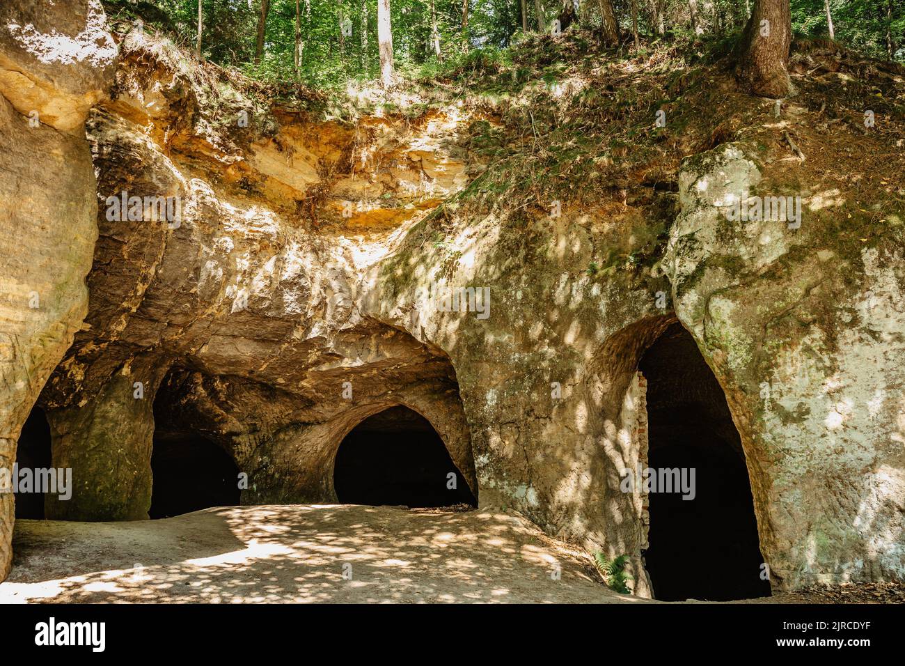 System of caves in sandstone rocks called Puste kostely, Czech republic.Entrance to large underground quarry.Popular tourist attraction.Czech nature. Stock Photo