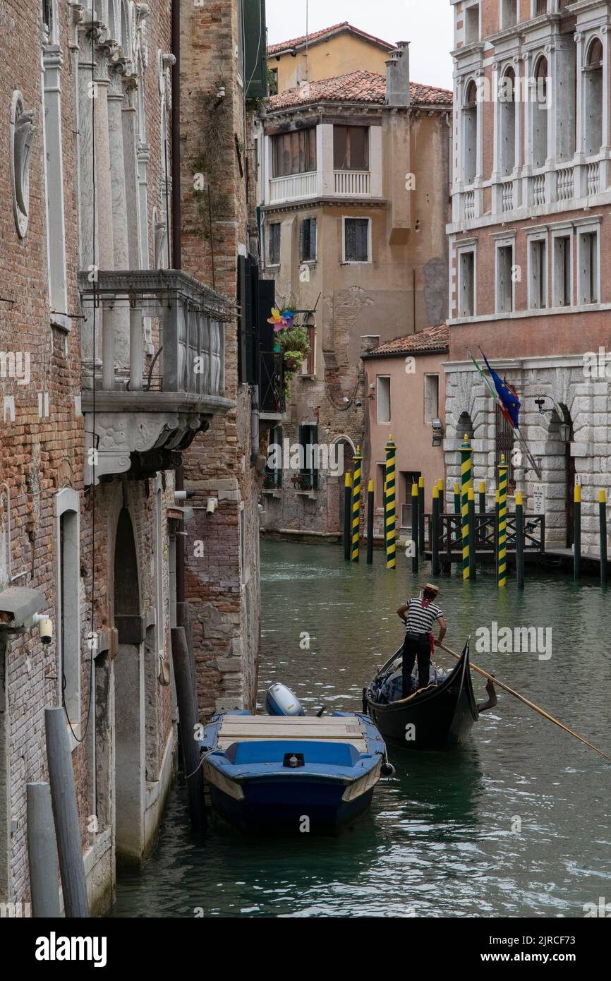 Gondolas and boats at a water channel in Venice, Italy Stock Photo - Alamy