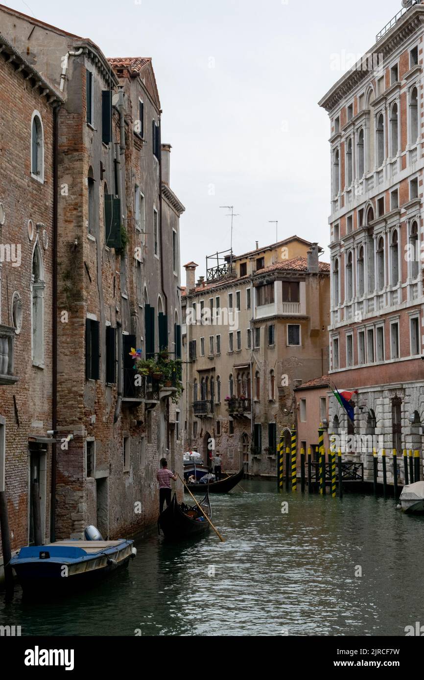 Gondolas and boats at a water channel in Venice, Italy Stock Photo - Alamy