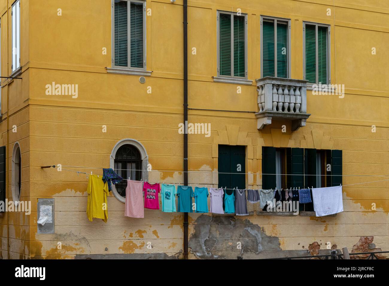 A yellow house with drying clothes in Giudecca Island, Venice Stock Photo